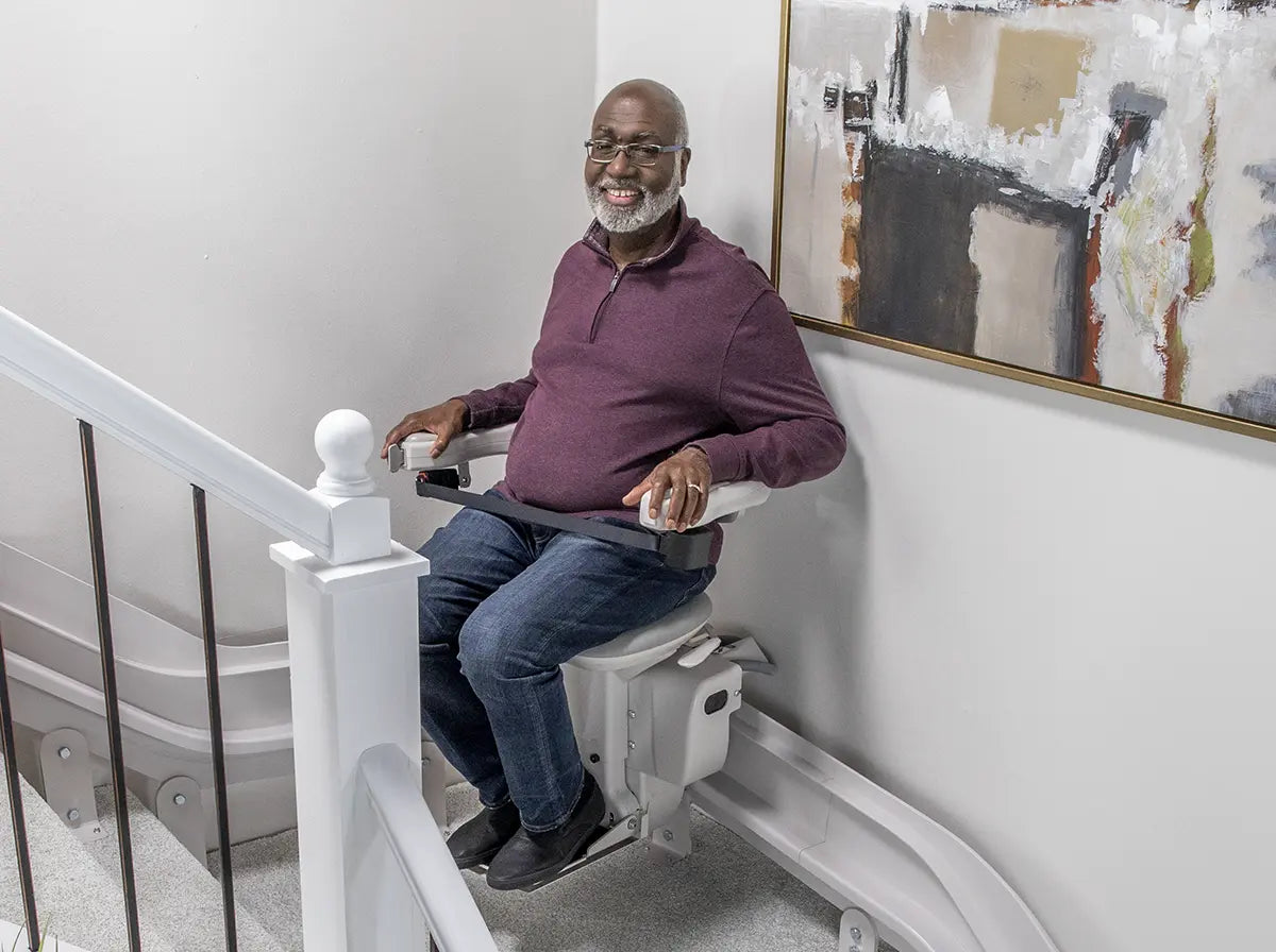 Man using a curved custom stair lift in home