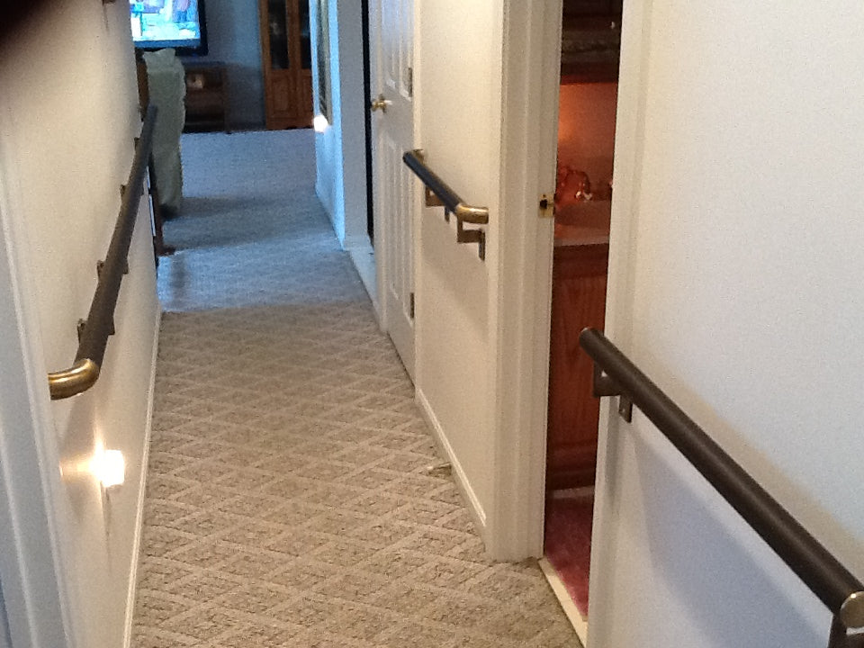 Hallway with carpeted floor and handrails on walls

